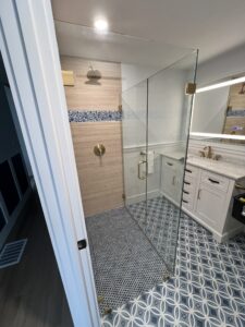 A newly renovated bathroom with a glass shower enclosure.